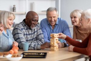 An older adult organizing clothes and personal items in a cozy, well-lit room with help from a family member.